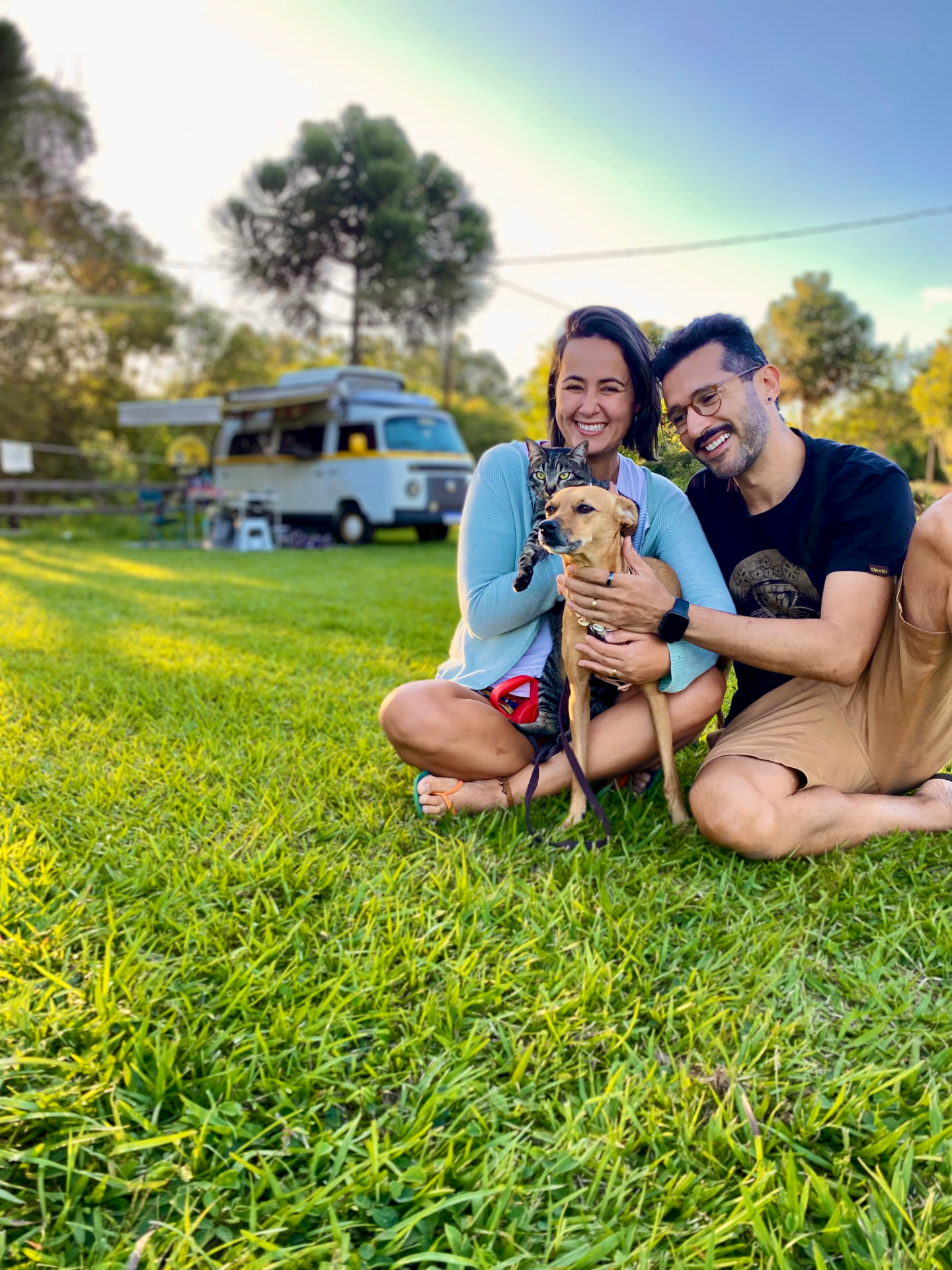 Daniel, Ana, o gato Sivuca e a cachorrinha Mari em frente à antiga Kombi Home